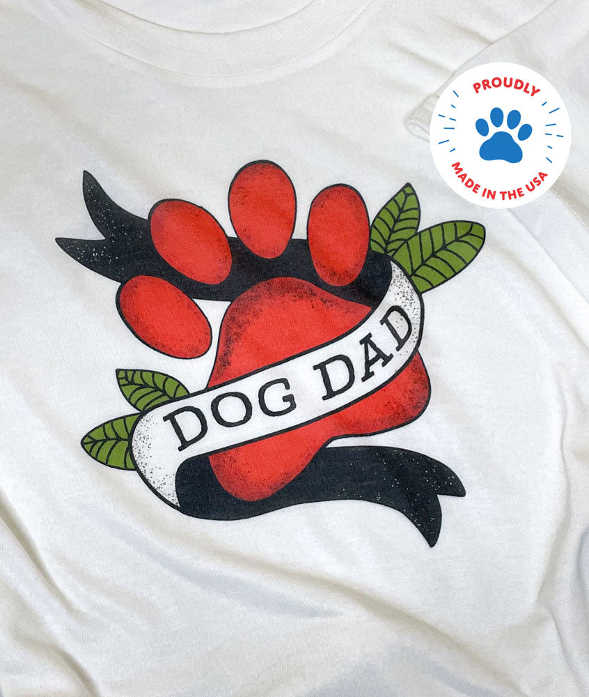 White t-shirt with Dog Dad Paw Tattoo Banner that reads DOG DAD and Proudly Made in the USA